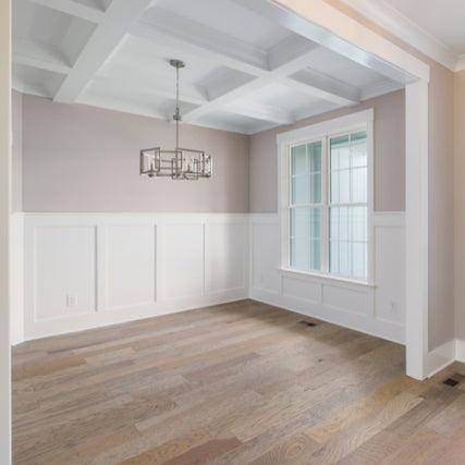 MillworkAn interior room with decorative white baseboard and millwork against a beige wall.